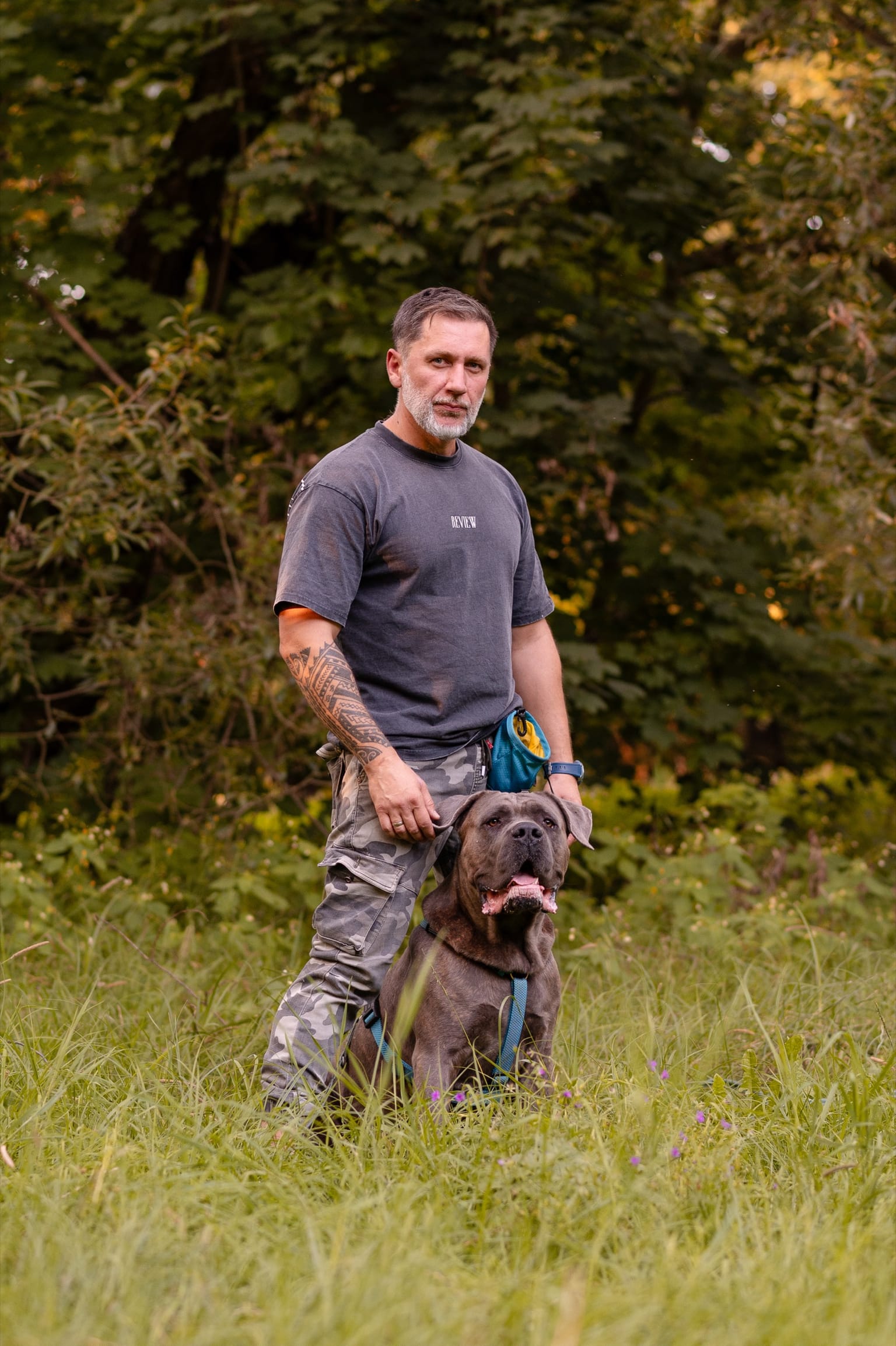 Paweł Piotrowicz z Marcelem, cane corso, na łące